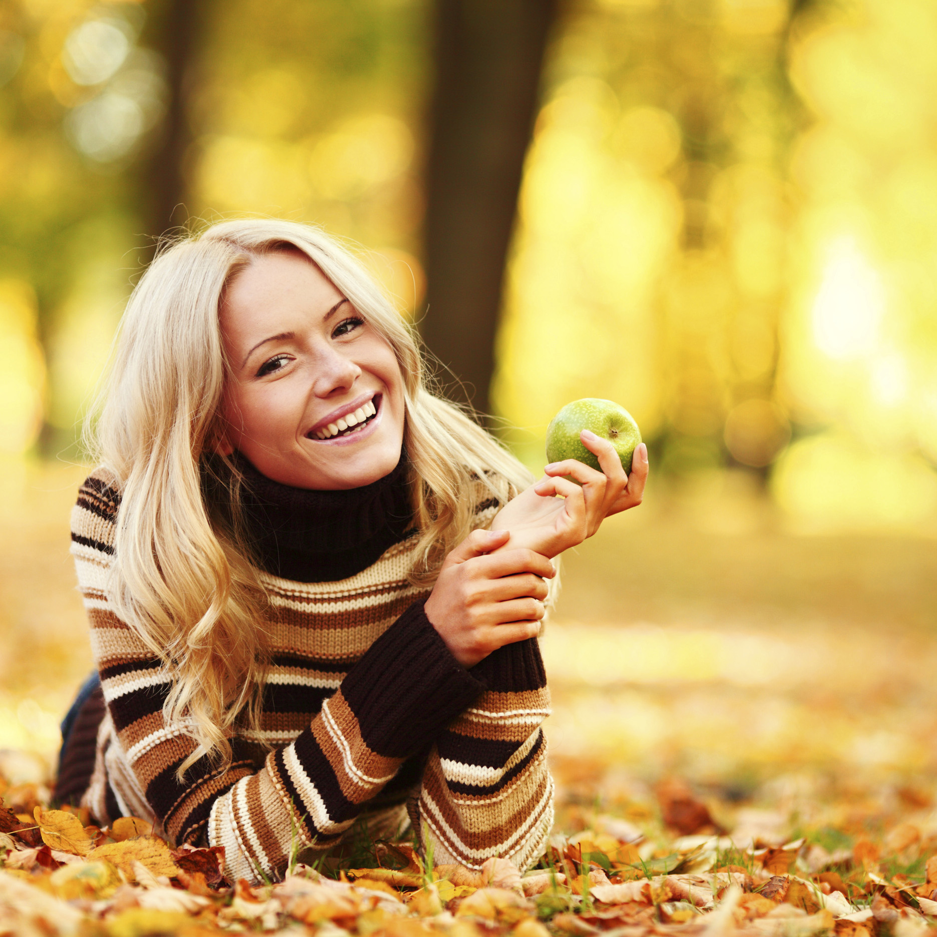 woman eat apple in autumn park